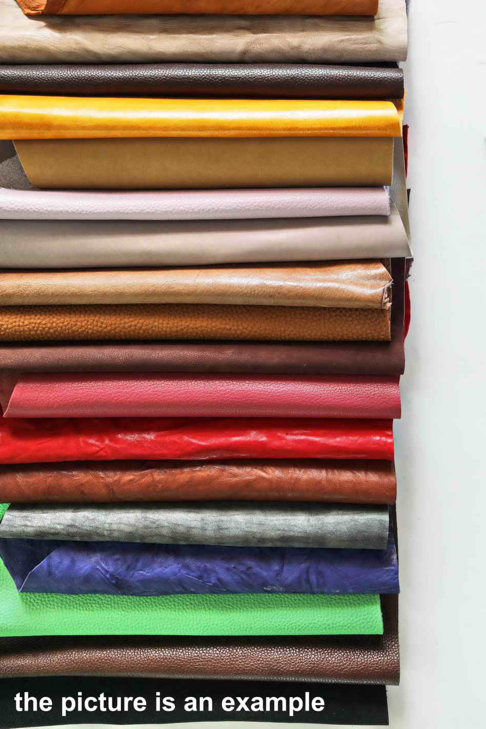 Può includere: Un set di campioni di pelle di diversi colori. I campioni sono disposti in una pila verticale, con il campione superiore di colore marrone chiaro e il campione inferiore di colore marrone scuro. I campioni sono di diverse trame e spessori.
