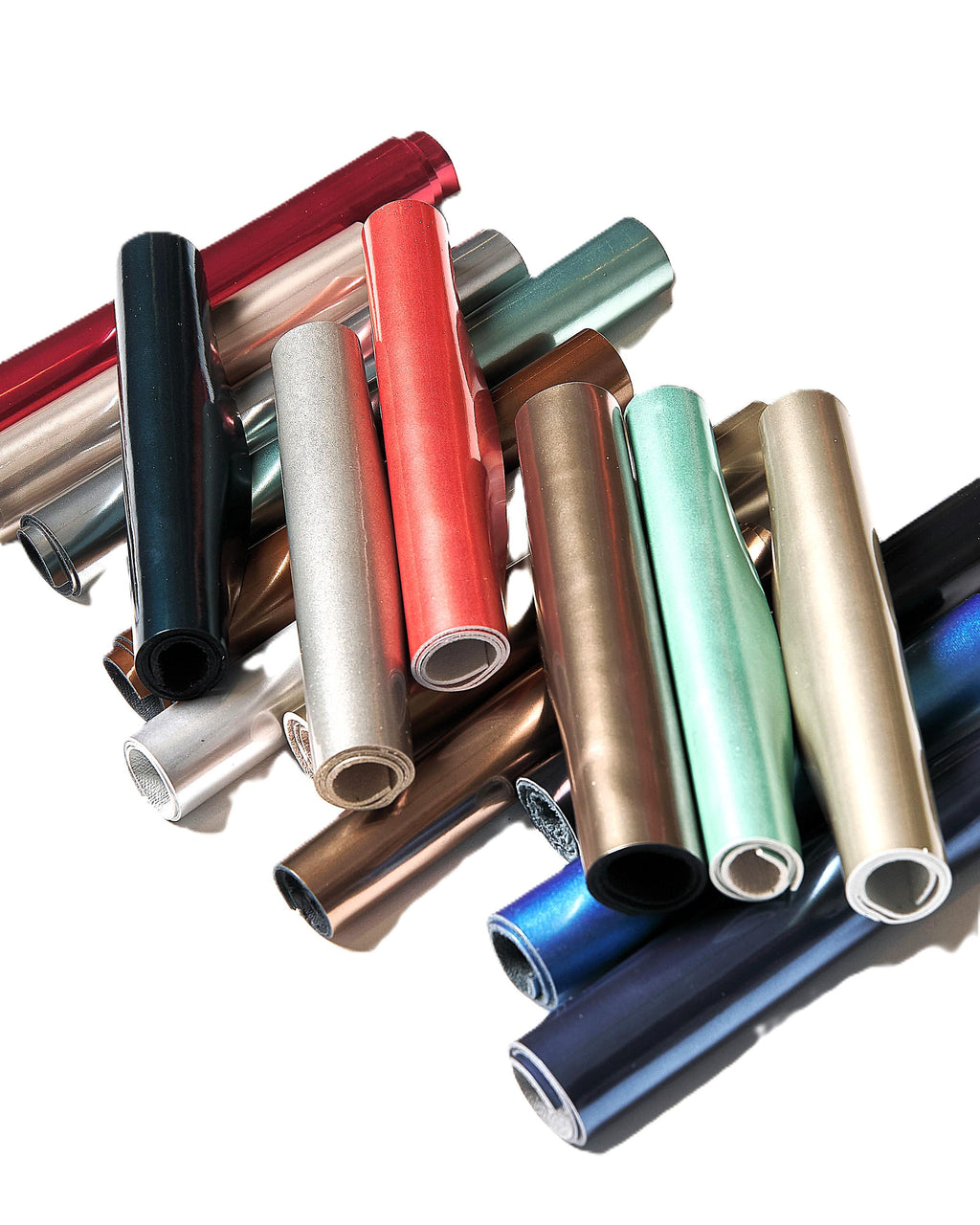 Può includere: Una collezione di fogli di vinile arrotolati in vari colori, tra cui rosso, argento, verde acqua e oro. I rotoli sono ben avvolti, rivelando la finitura lucida e metallica del materiale. L'immagine è ben illuminata, evidenziando le trame e i colori.