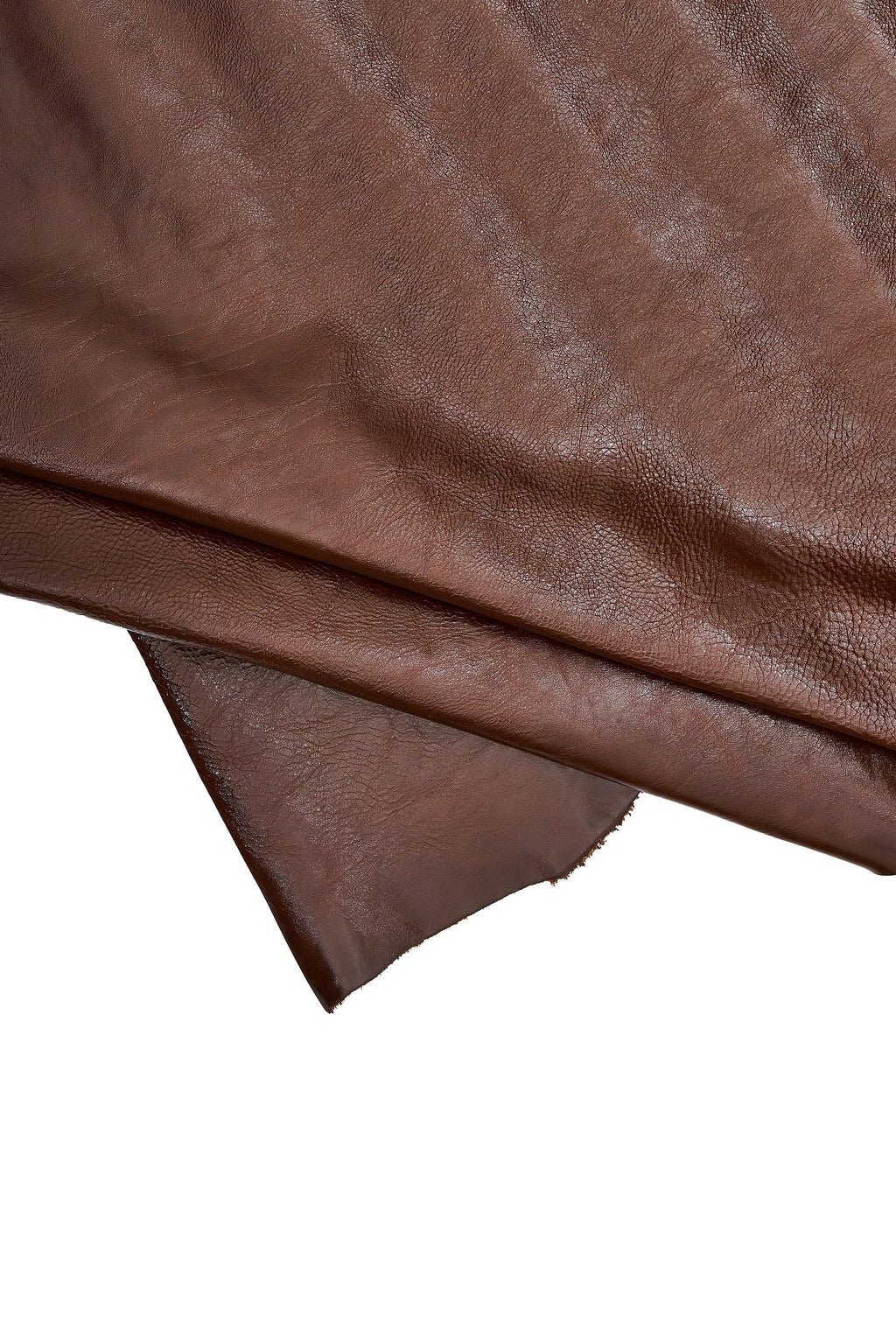 Può includere: Primo piano di un foglio di pelle marrone. La pelle ha una superficie strutturata con sottili variazioni di colore e tono. I bordi della pelle sono visibili, mostrando lo spessore e la consistenza del materiale. La pelle è ripiegata su se stessa.