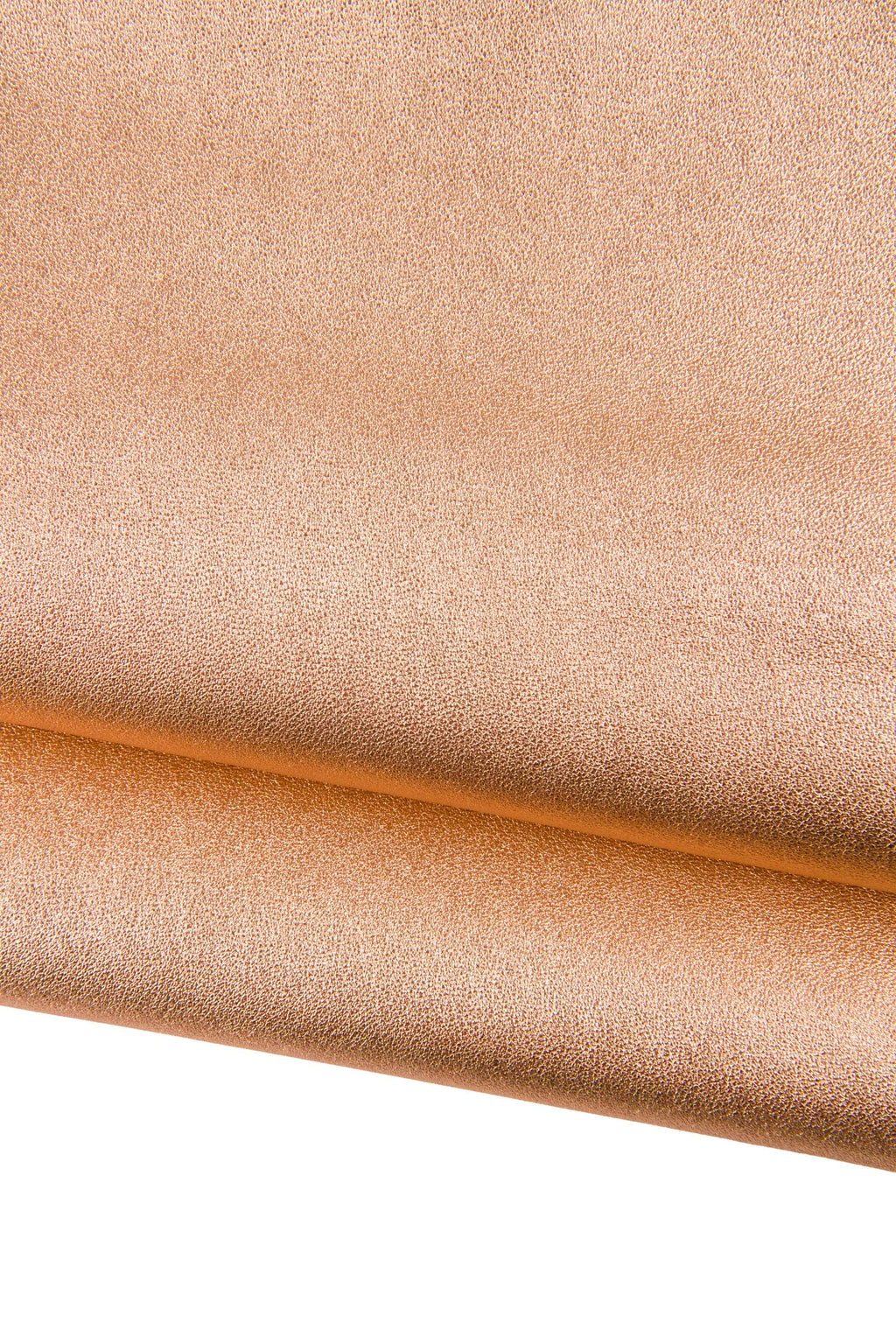 Può includere: Primo piano di un tessuto strutturato con un aspetto metallico in un caldo color rame. Il materiale è piegato, rivelando uno scorcio del lato inferiore. La superficie presenta un motivo sottile e maculato, che suggerisce pelle o similpelle. Ideale per progetti di artigianato o moda.