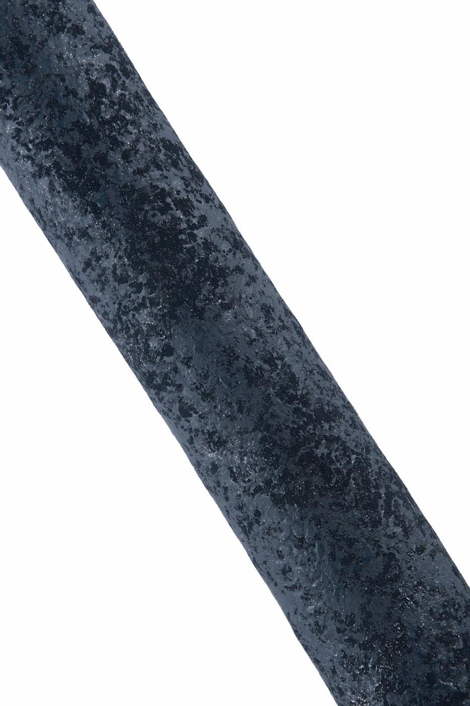 Può includere: Primo piano di un oggetto grigio scuro strutturato con una superficie ruvida e macchiata. L'oggetto è posizionato diagonalmente su uno sfondo bianco. La trama suggerisce un materiale in pietra o metallo.