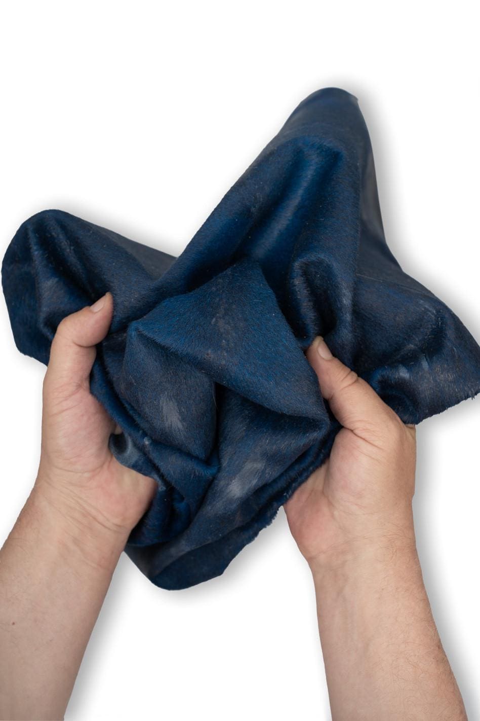 Può includere: Un pezzo di pelle blu scuro con una visibile consistenza di pelo. Il materiale è piegato e increspato, mostrando un colore blu navy profondo con sottili variazioni di tono e una morbida lucentezza naturale sulla superficie della pelle.