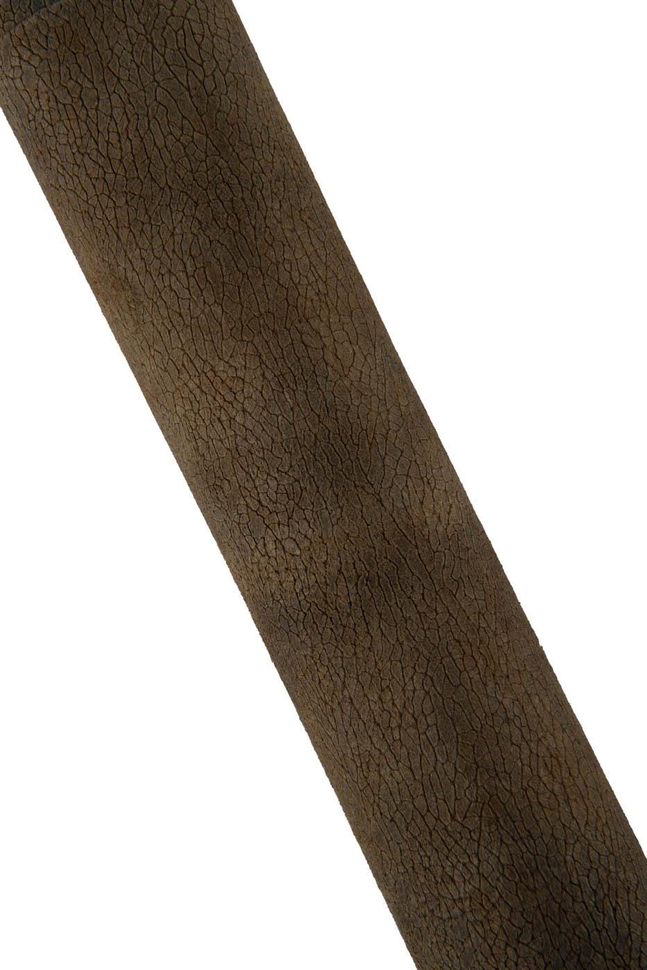 Può includere: Un oggetto cilindrico caratterizzato da una superficie marrone scuro con una distinta texture screpolata a grana fine che copre l'intera lunghezza visibile. Il motivo consiste in una fitta rete di piccole linee irregolari.