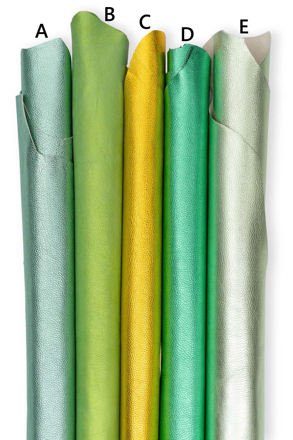 Può includere: Cinque rotoli verticali di pelle testurizzata etichettati da A a E. Il rotolo A è verde menta chiaro, B è verde lime, C è oro metallizzato, D è verde smeraldo e E è un verde argenteo pallido. Ogni rotolo mostra una grana e finitura metallica.