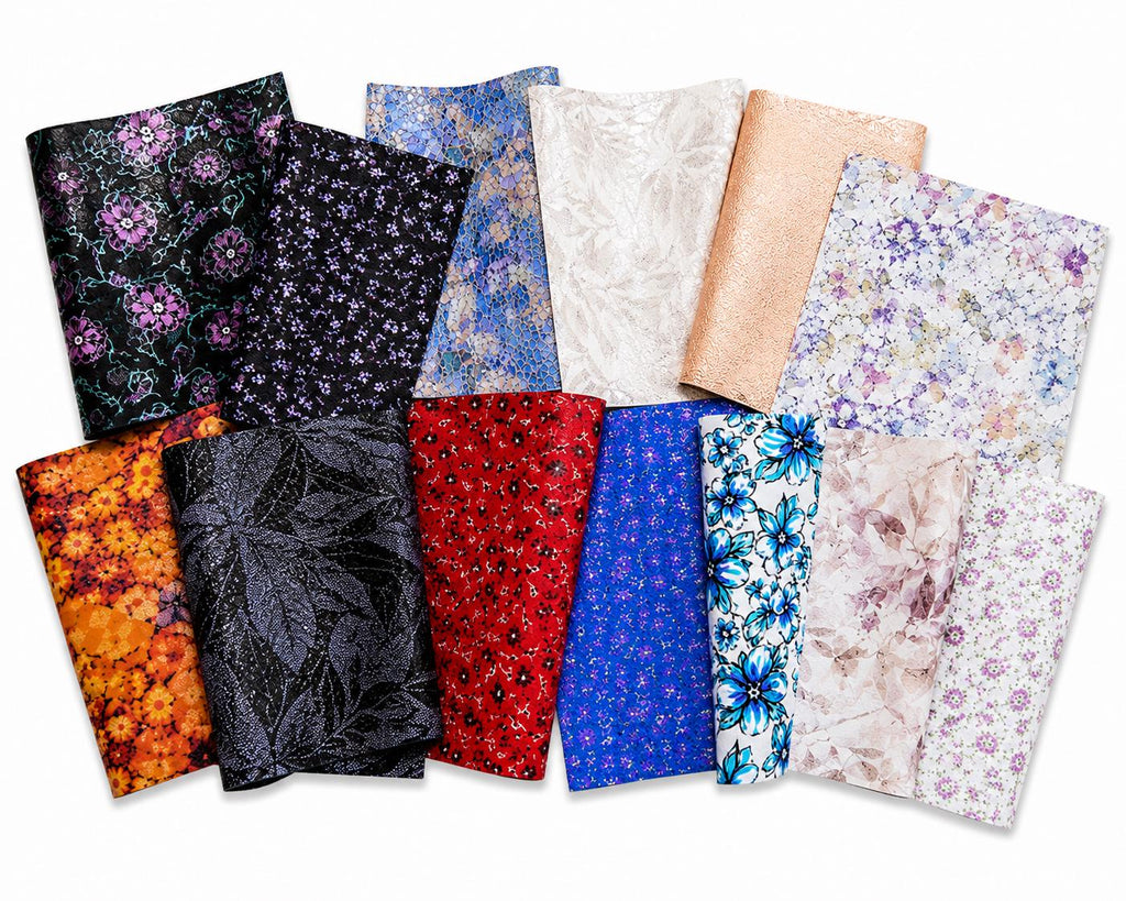 Può includere: Una collezione di dodici fogli rettangolari di tessuto in similpelle con vari motivi e texture, tra cui stampe floreali in nero, arancione, rosso e blu, oltre a finiture in oro metallizzato, bianco e blu e nero testurizzato.