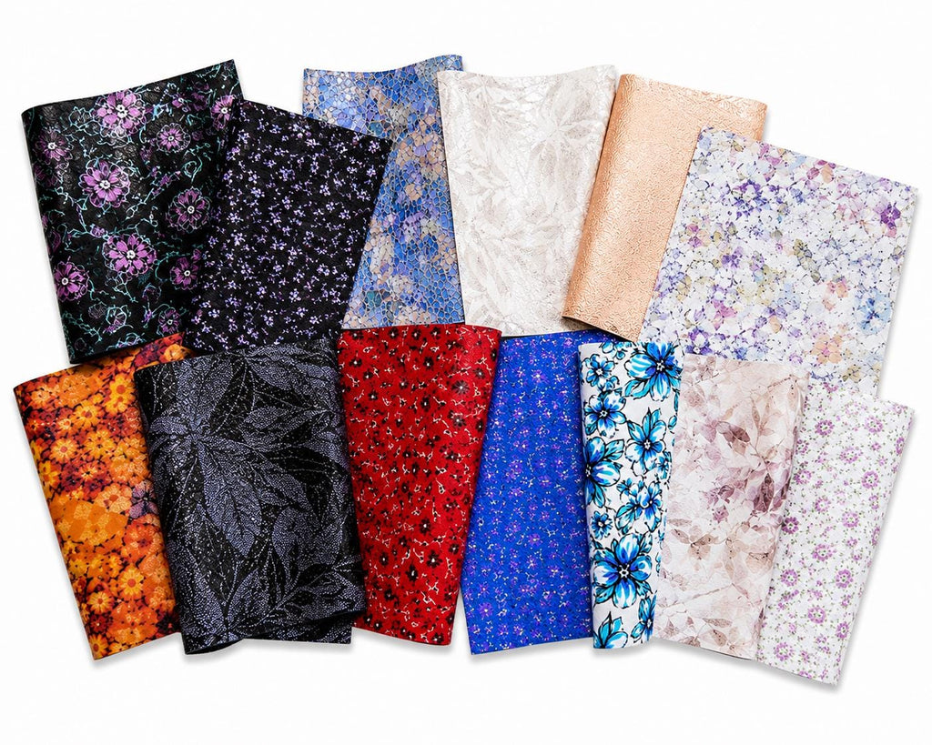 Può includere: Una collezione di dodici fogli rettangolari di tessuto in similpelle con vari motivi e texture, tra cui stampe floreali in nero, arancione, rosso e blu, oltre a finiture in oro metallizzato, bianco e blu e nero testurizzato.
