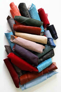 Può includere: Una collezione di ritagli di pelle di vari colori, tra cui rosso, blu, marrone e nero. La pelle è arrotolata e disposta in un mucchio.
